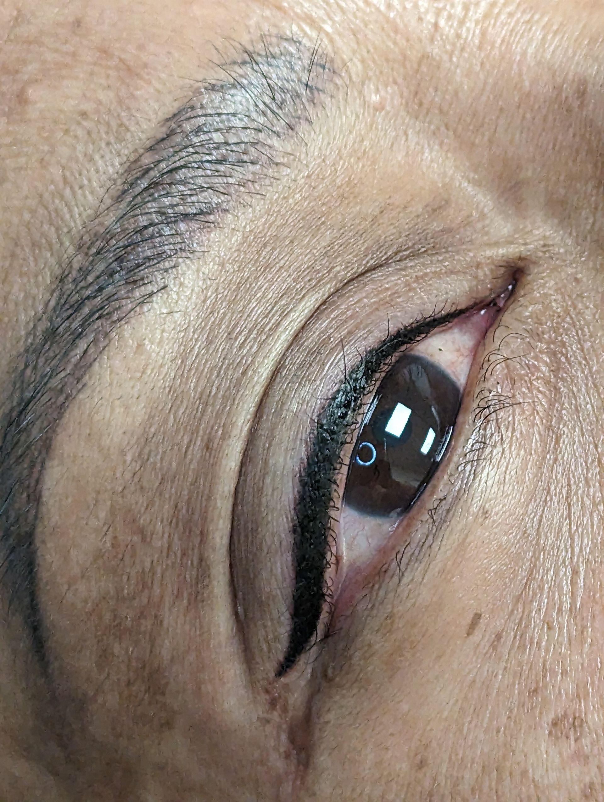 A close up of a woman 's eye with eyeliner and eyebrows.