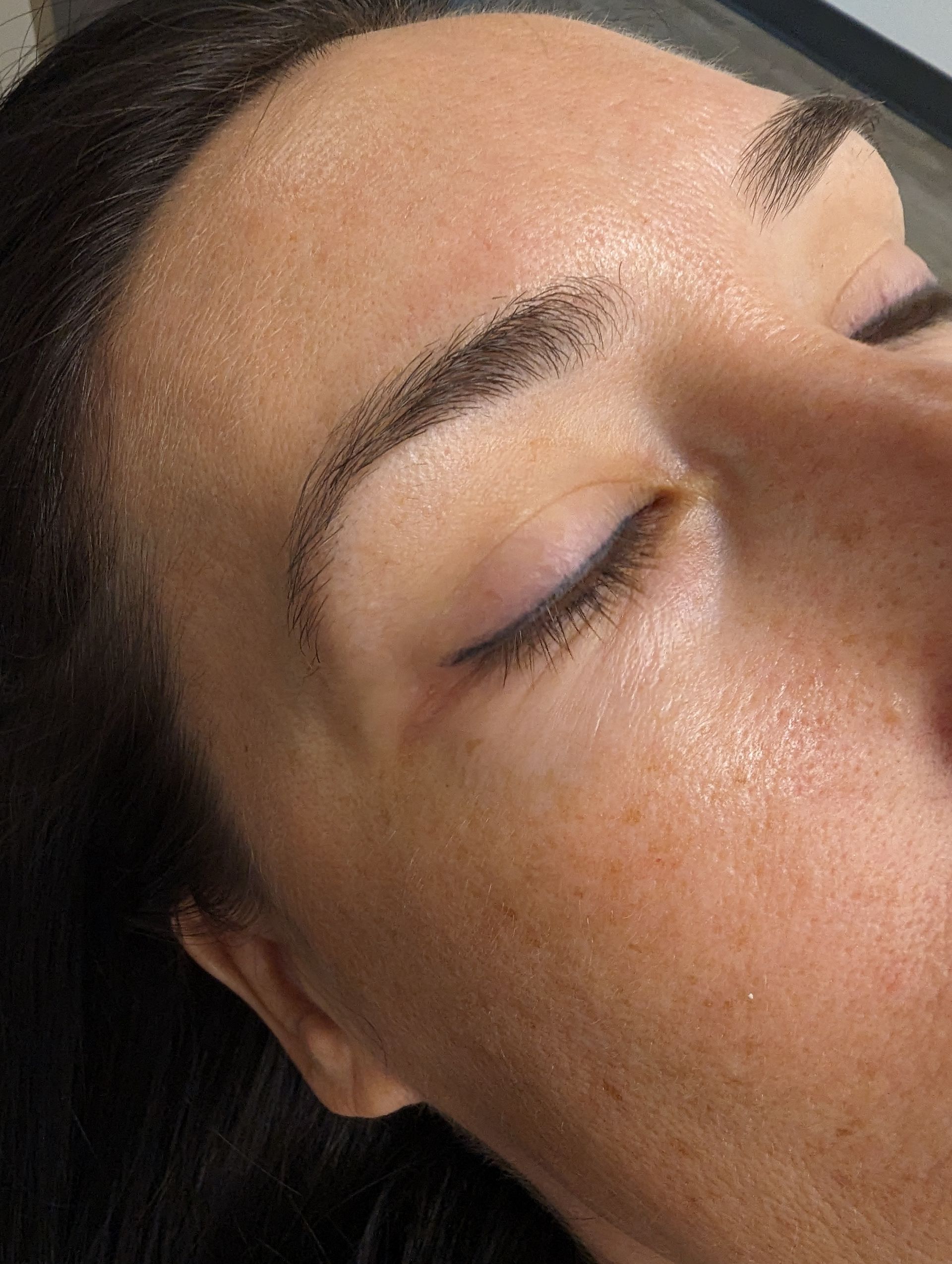 A close up of a woman 's face with her eyes closed.