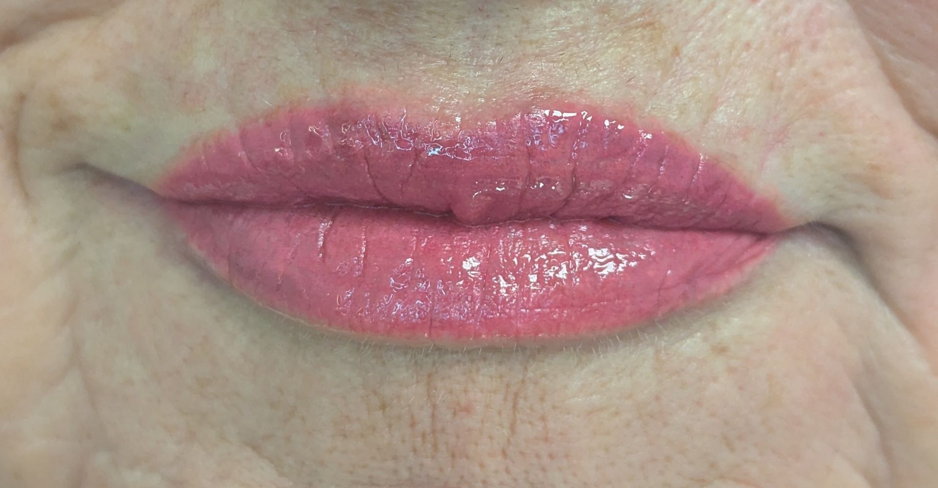 A close up of a woman 's lips with pink lipstick.