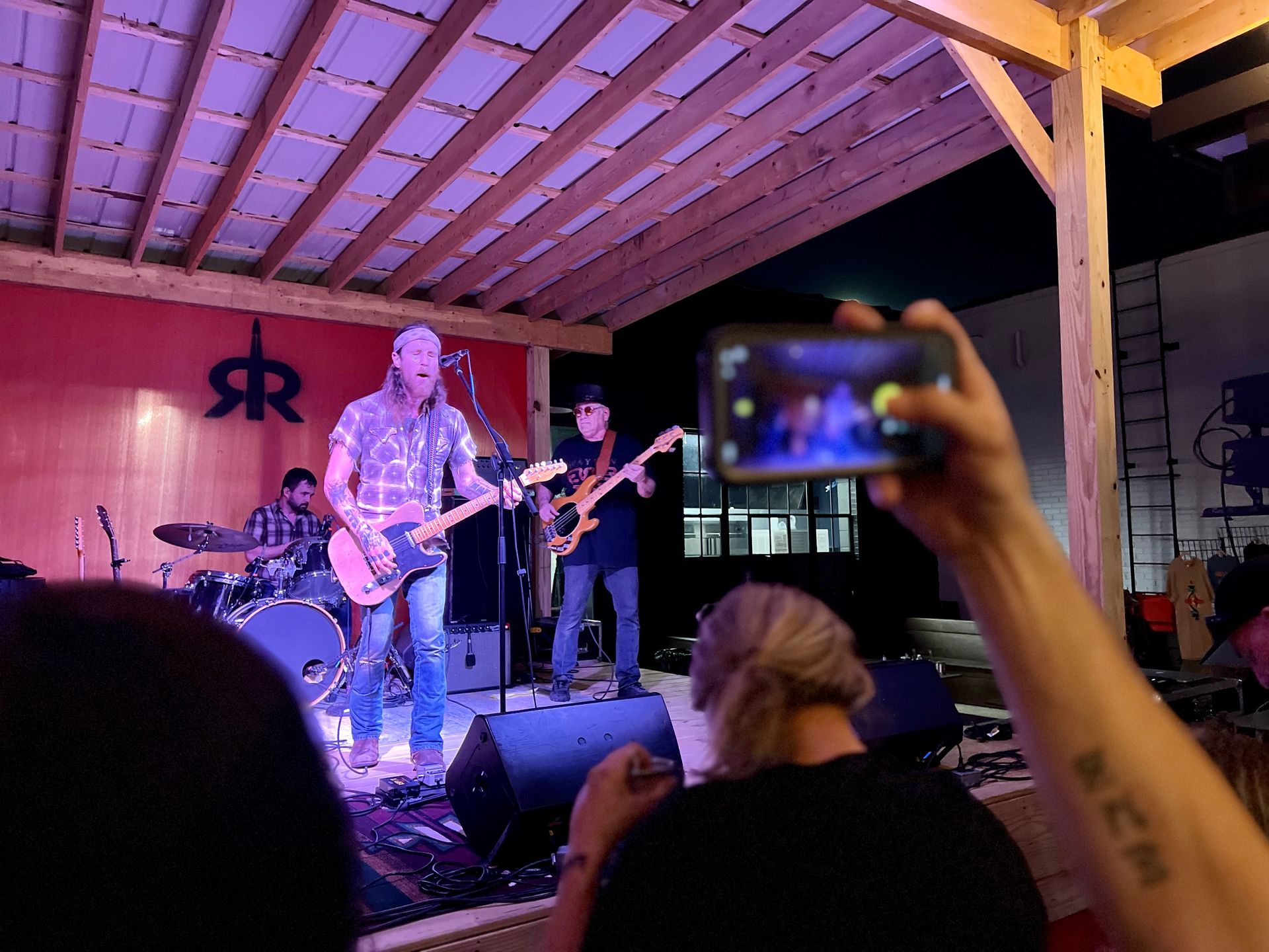 A person is taking a picture of a band on stage.