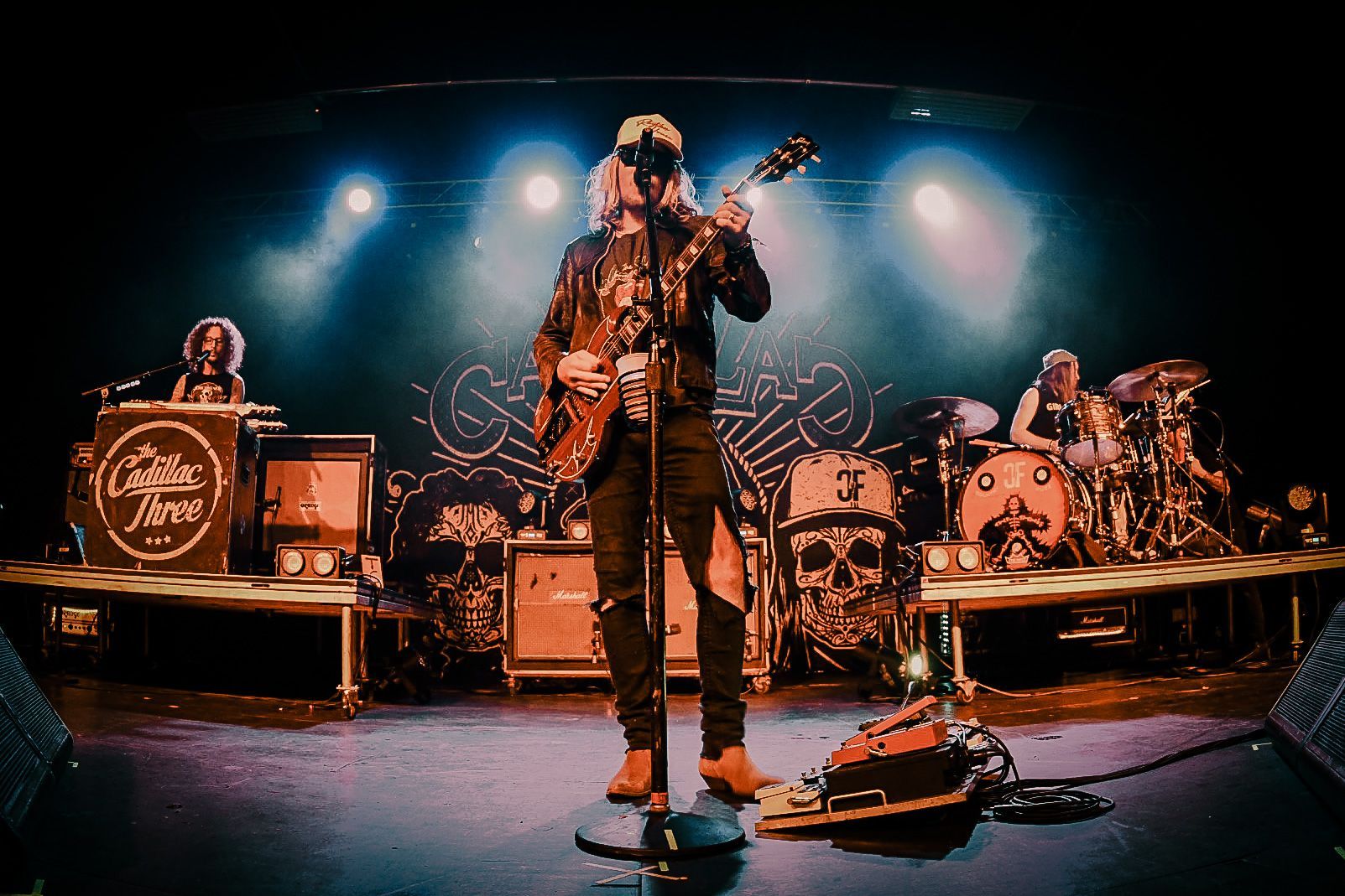 A man is playing a guitar and singing into a microphone on a stage.