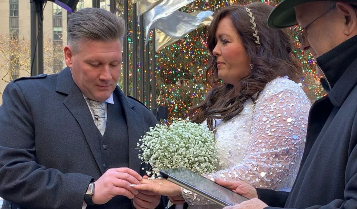 a groom placing the ring on his new wife's finger at their wedding ceremony