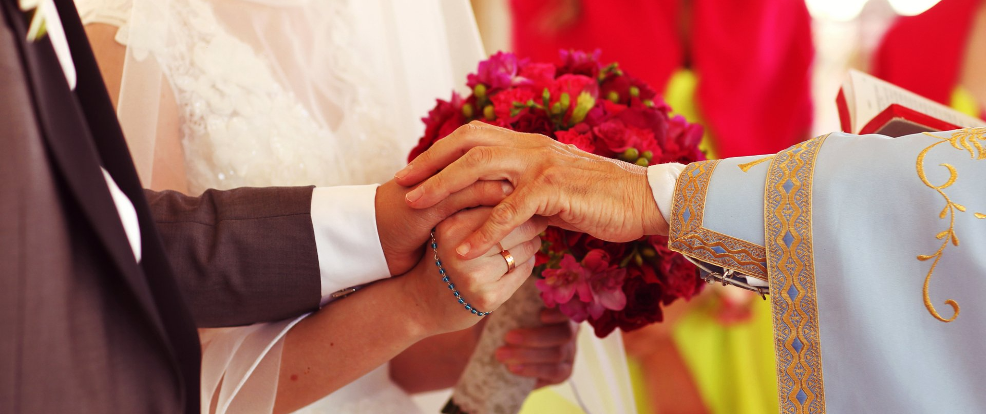 a priest holding the hands of the bride and groom