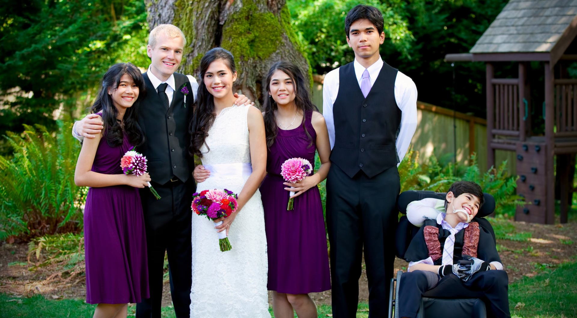 newlyweds pose for photo with family and brother with wheelchair