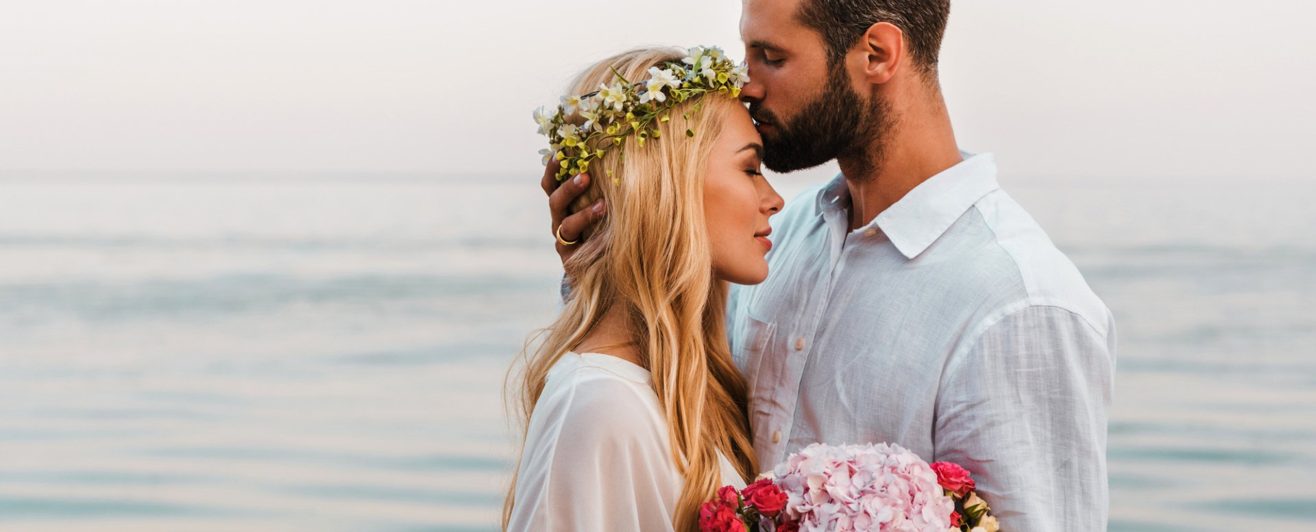 groom kissing his bride on the forehead