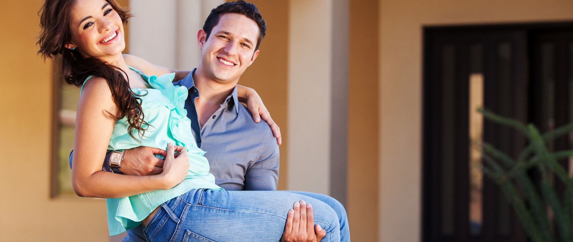 beautiful couple in front of their new house