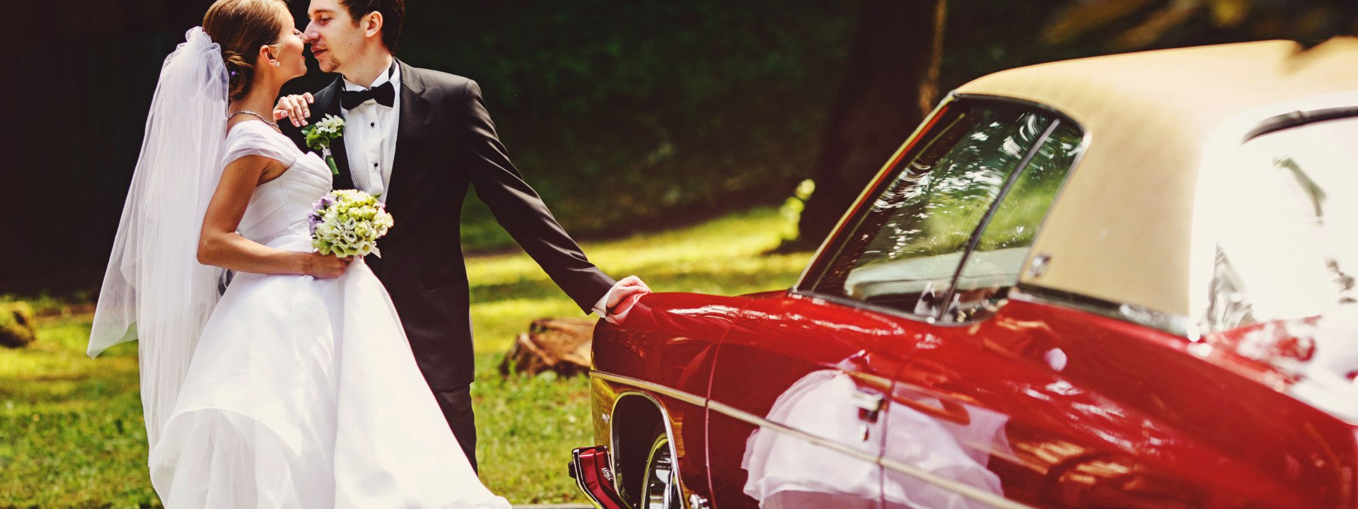 newlywed couple with a red vintage car