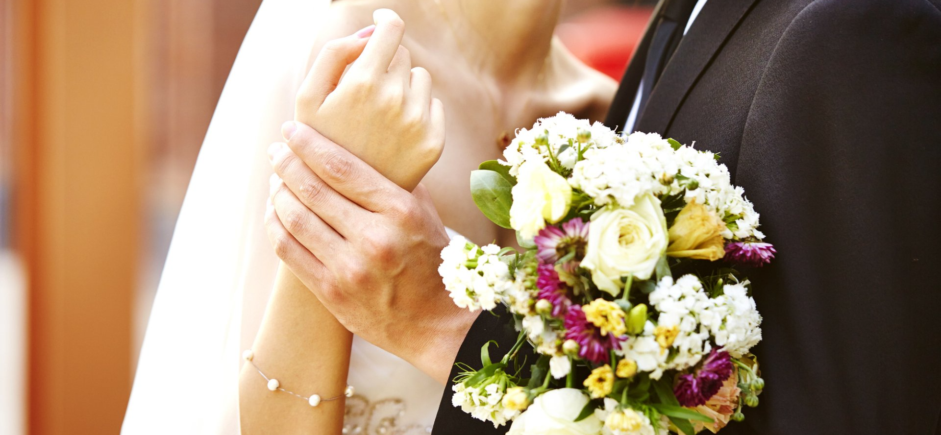 couple holding hands with bouquet