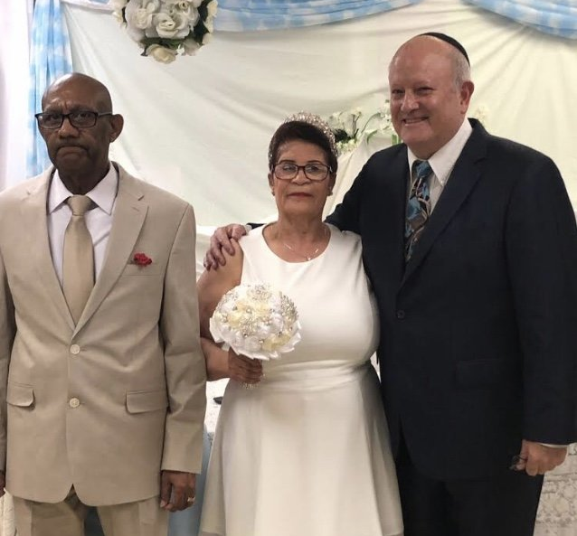 elderly couple with wedding officiant at vow renewal ceremony