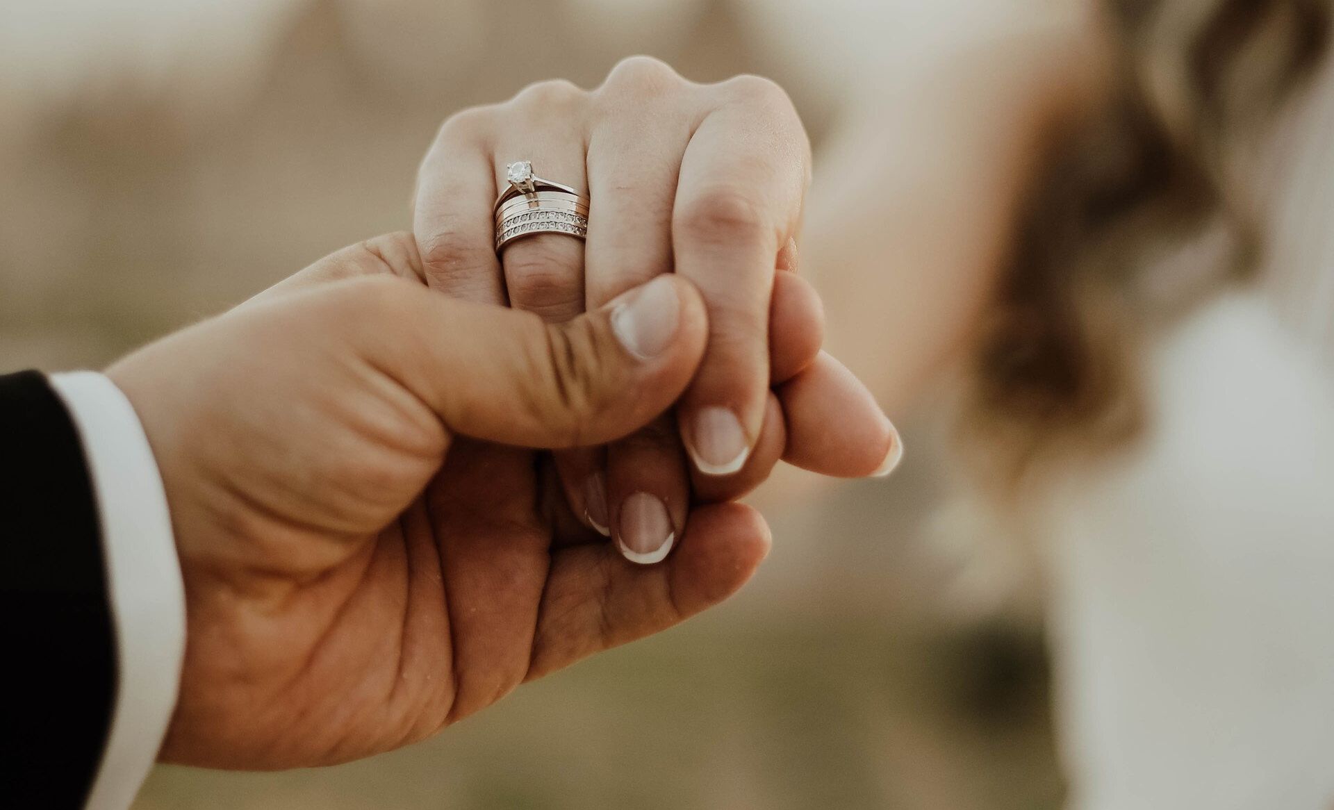 the groom holds his bride's hand in their unity ceremony