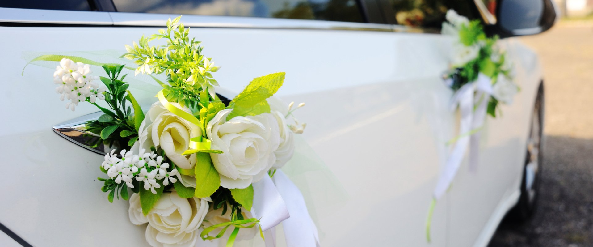 a pure white wedding limo with floral decor