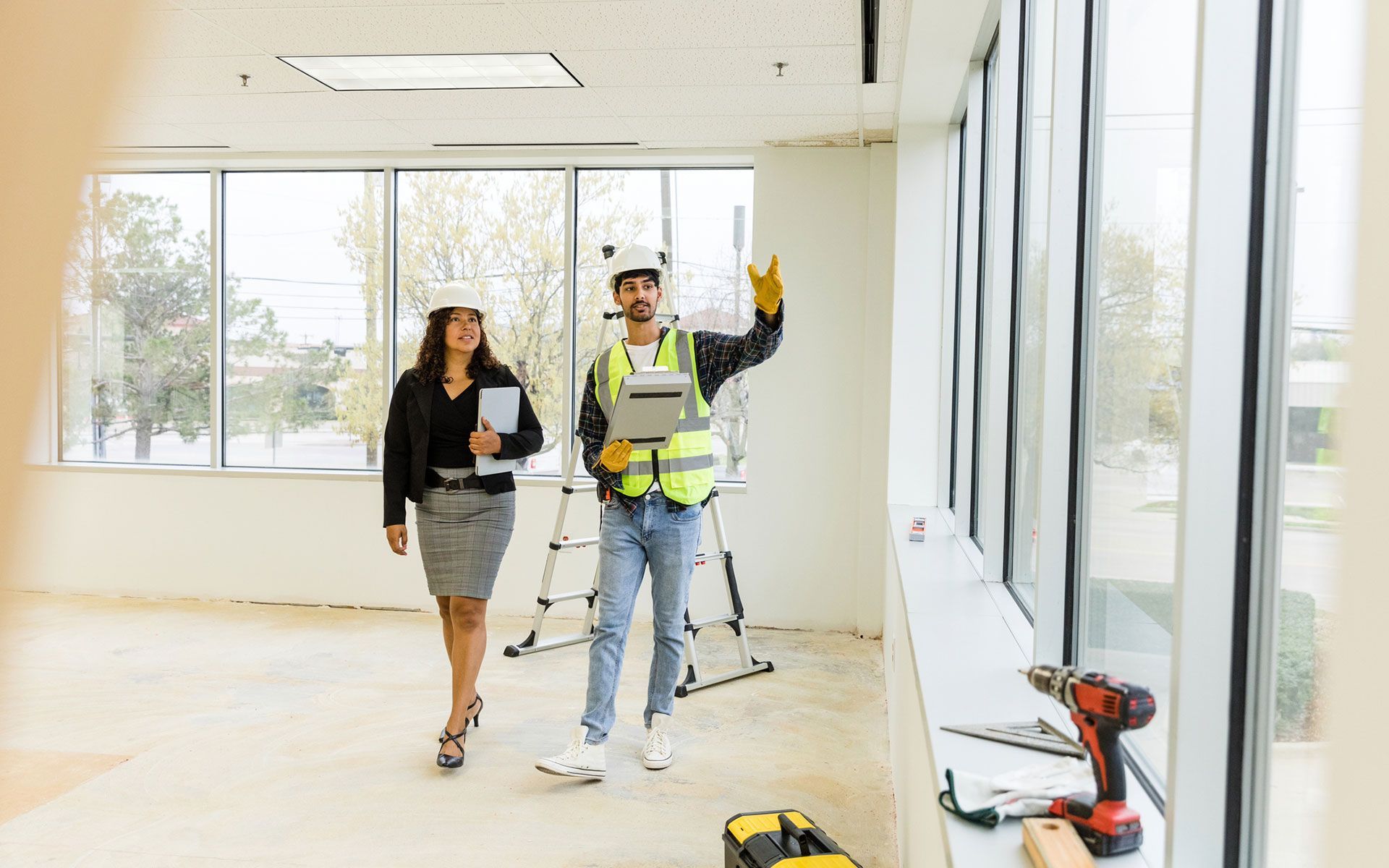 A man and a woman are walking through an empty room.
