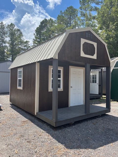 A brown barn with a porch and a white door