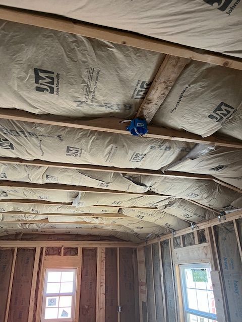 A room with a ceiling that is covered in insulation and a window.
