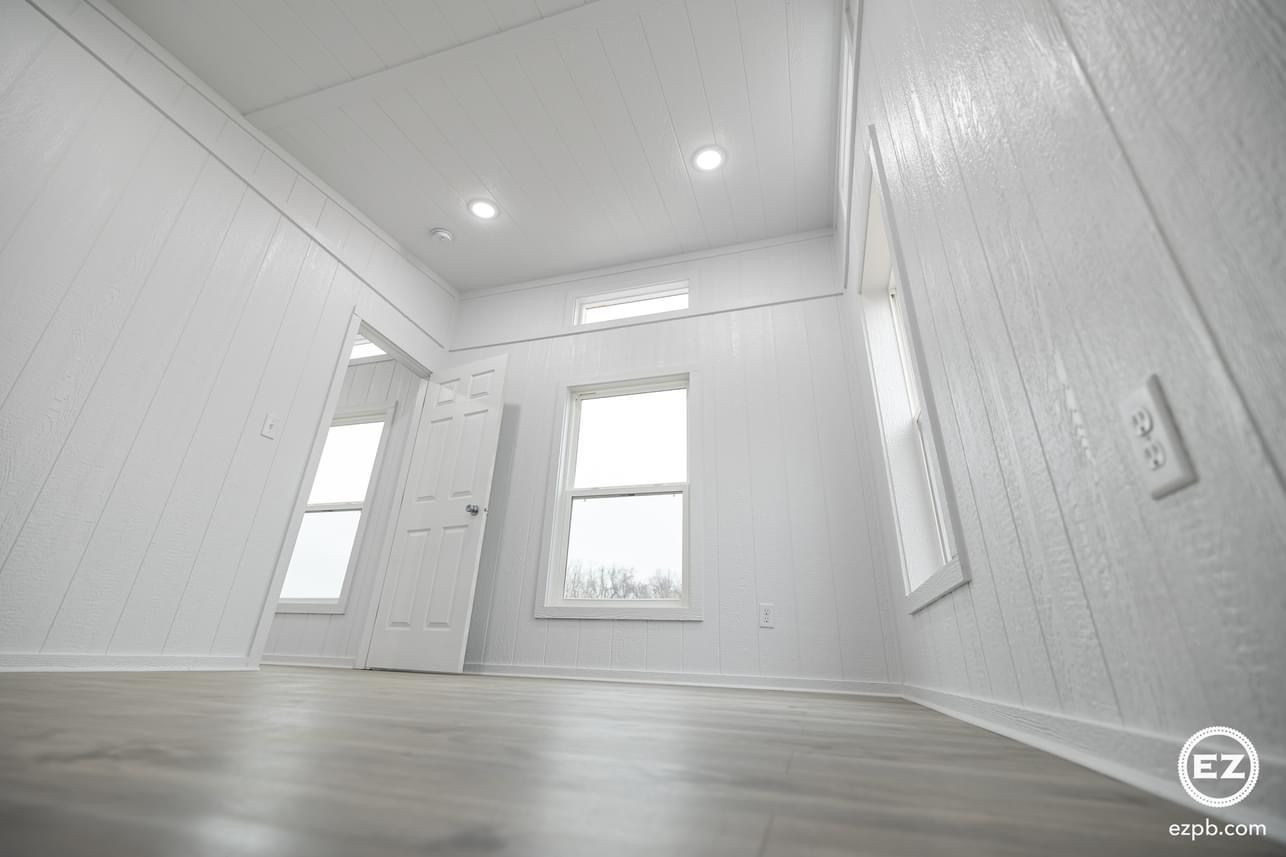 An empty room with white walls and hardwood floors.