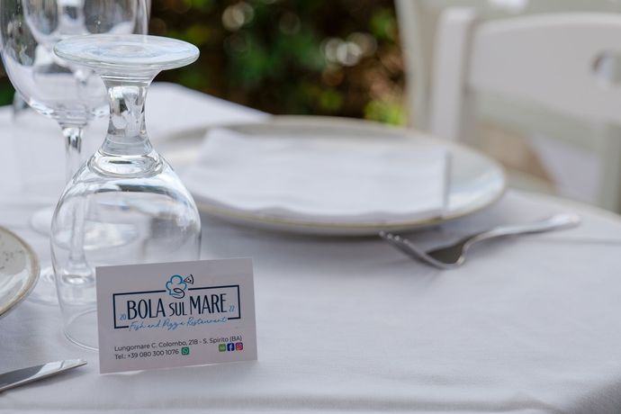 Apparecchiatura del tavolo con calice da vino, piatto e biglietto da visita per il ristorante