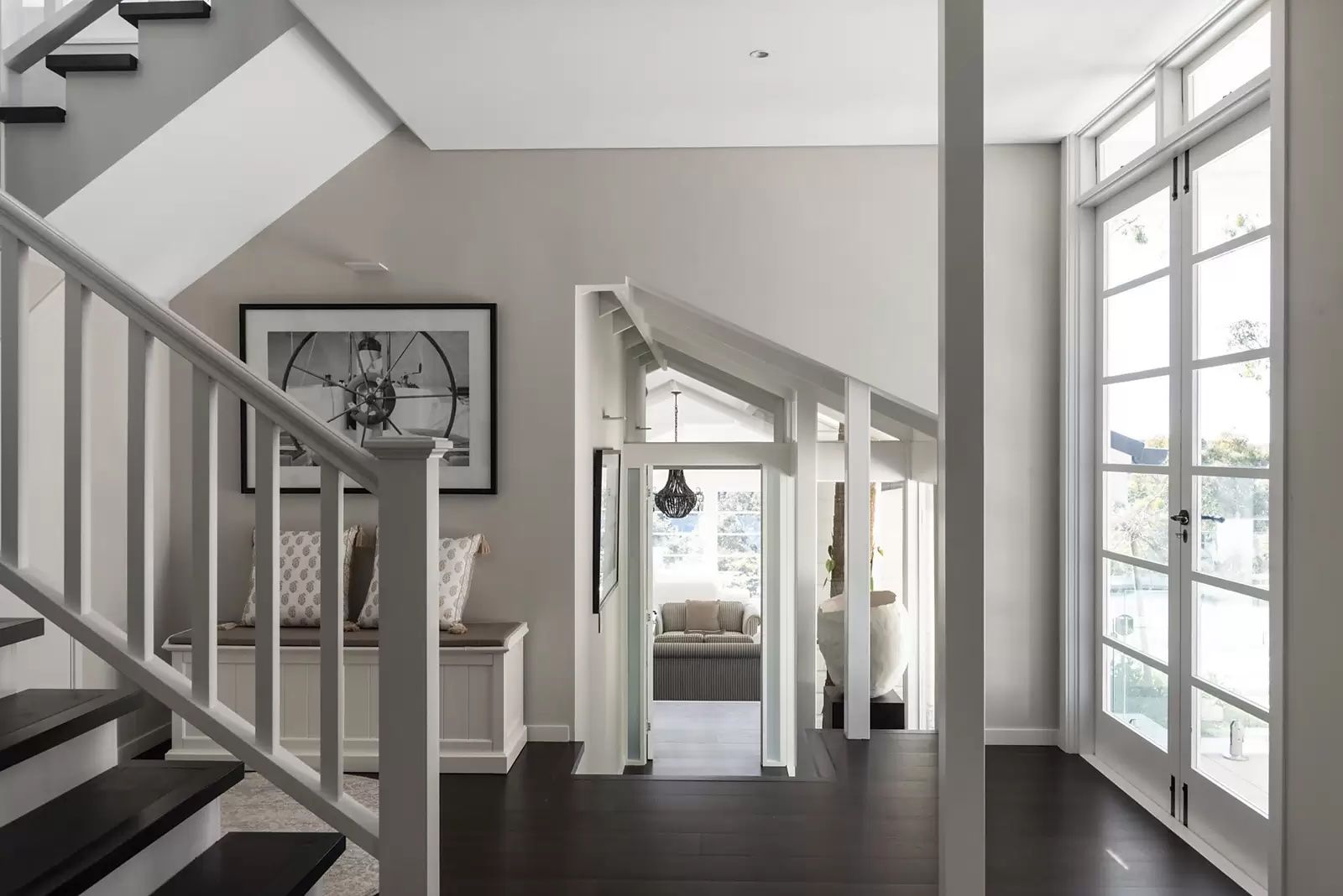 Bright modern foyer with staircase, framed art, and large windows  overlooking water — Fineworx Joinery in Warnervale, NSW
