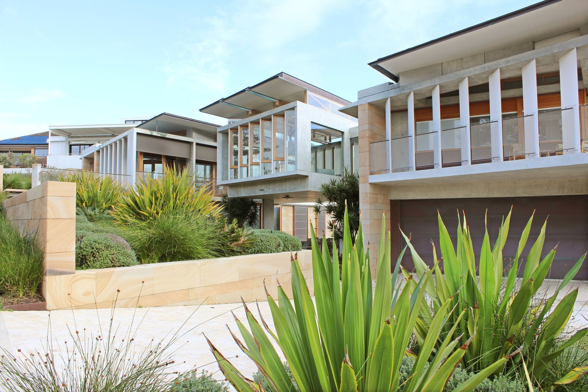 Modern apartment buildings with balconies and lush landscaping in bright daylight — Fineworx Joinery in Warnervale, NSW