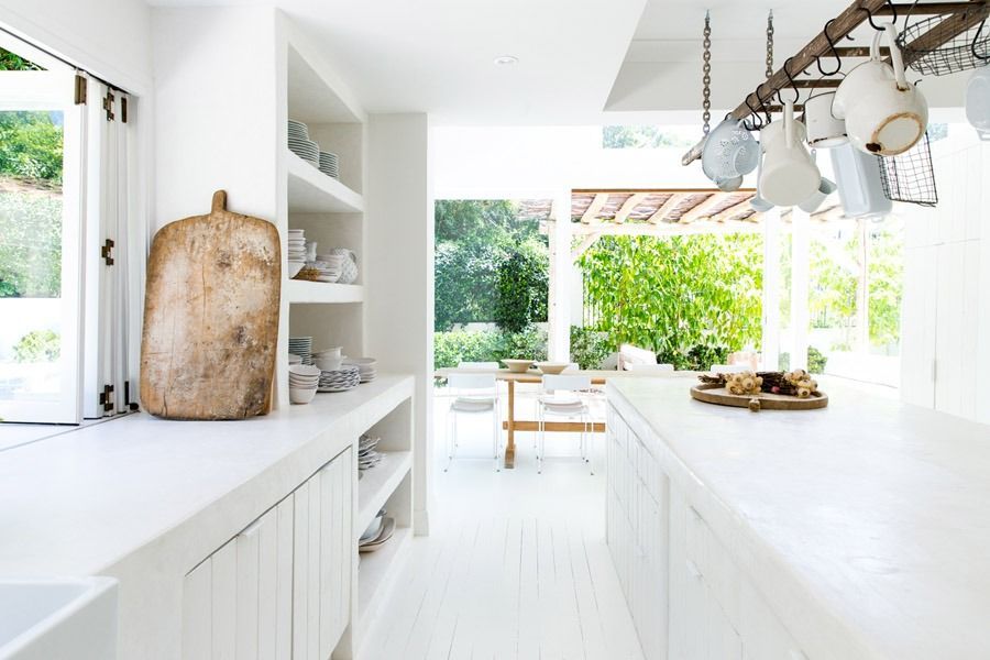 Bright White Kitchen with Hanging Lights and A Dining Area Opening to A Lush Garden — Fineworx Joinery in Warnervale, NSW