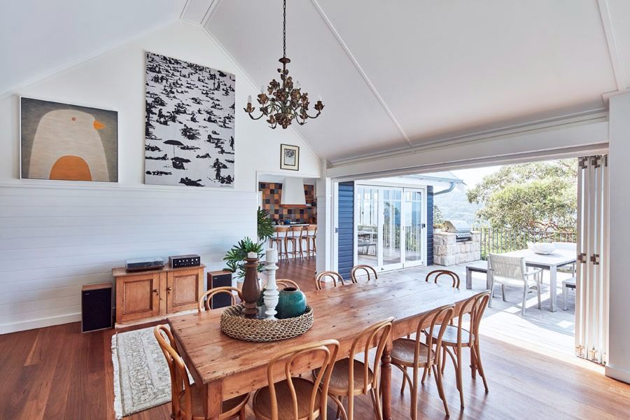 Bright Dining Room with Wooden Furniture and Open Folding Doors to A Patio — Fineworx Joinery in Warnervale, NSW