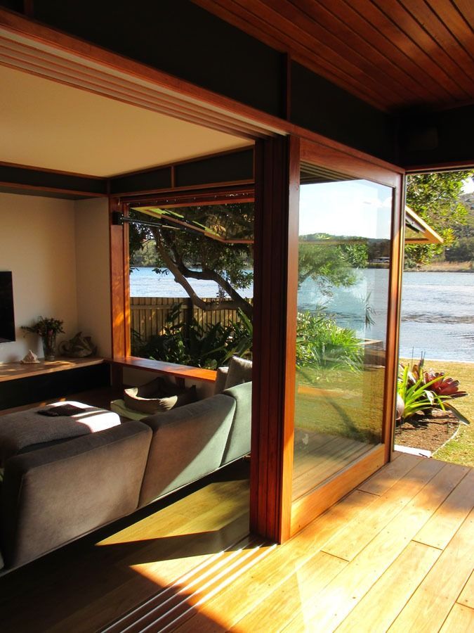 Sunlit Living Room with Open Glass Doors Overlooking a Bright Ocean View and Garden — Fineworx Joinery in Warnervale, NSW