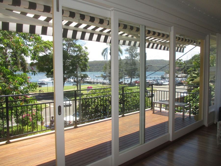 Sliding Glass Doors Open to A Balcony Overlooking a Waterfront — Fineworx Joinery in Warnervale, NSW