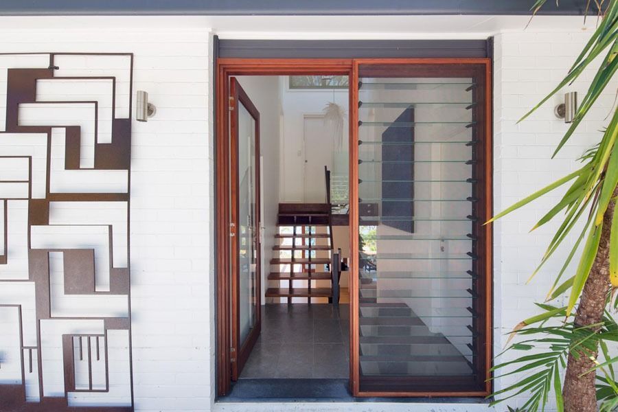 Front Entrance with Open Wooden Door and Decorative Metal Wall Art — Fineworx Joinery in Warnervale, NSW