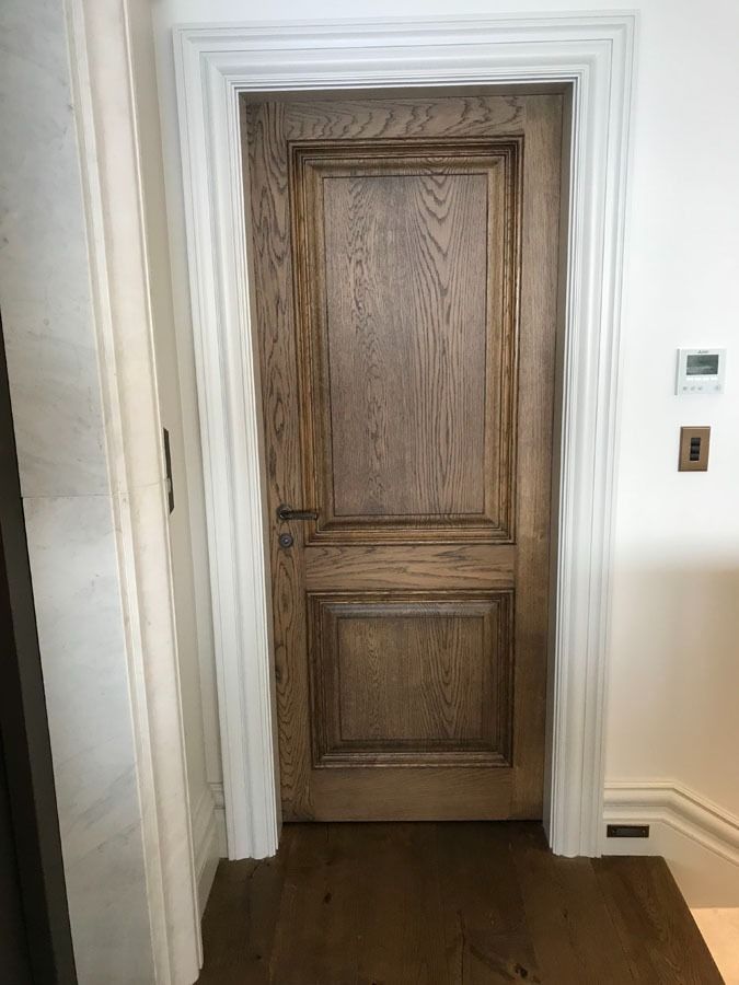 Closed Wooden Interior Door in A White Hallway with Dark Hardwood Floor — Fineworx Joinery in Warnervale, NSW