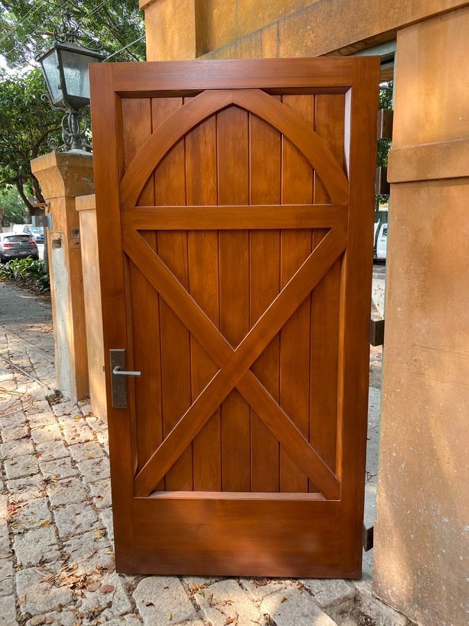 Wooden Arched Gate Door with Metal Handle Set in A Stone Wall — Fineworx Joinery in Sydney, NSW