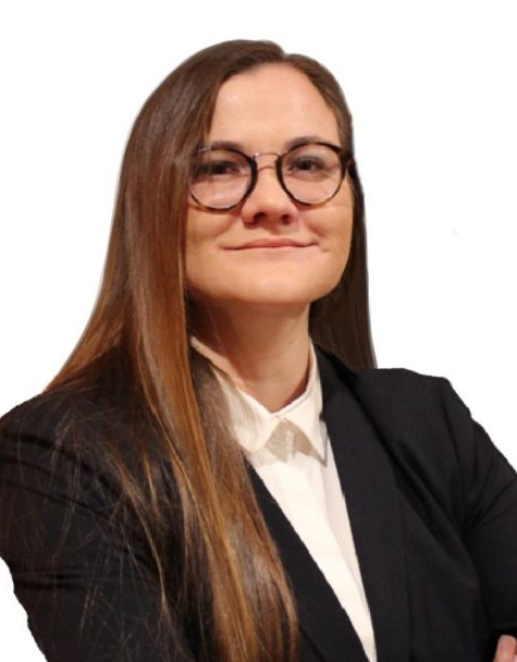 Woman with brown hair smiles, wearing a black blazer and white shirt.