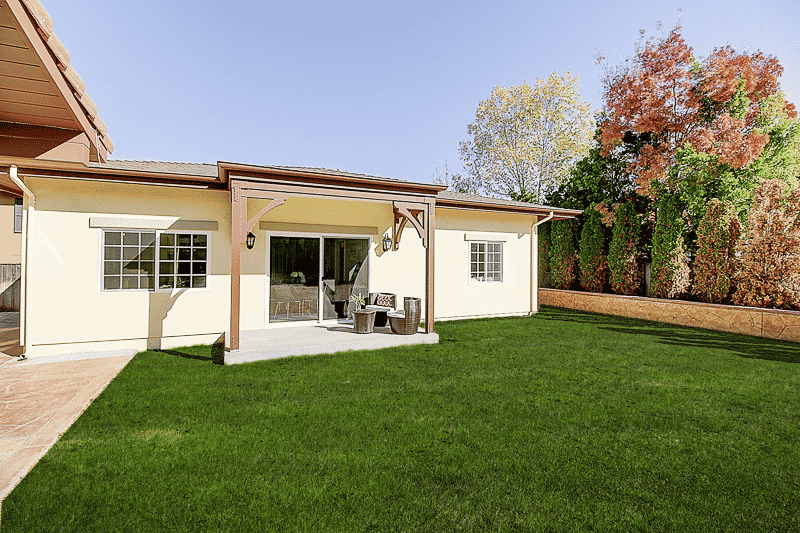 A house with a large lawn in front of it.