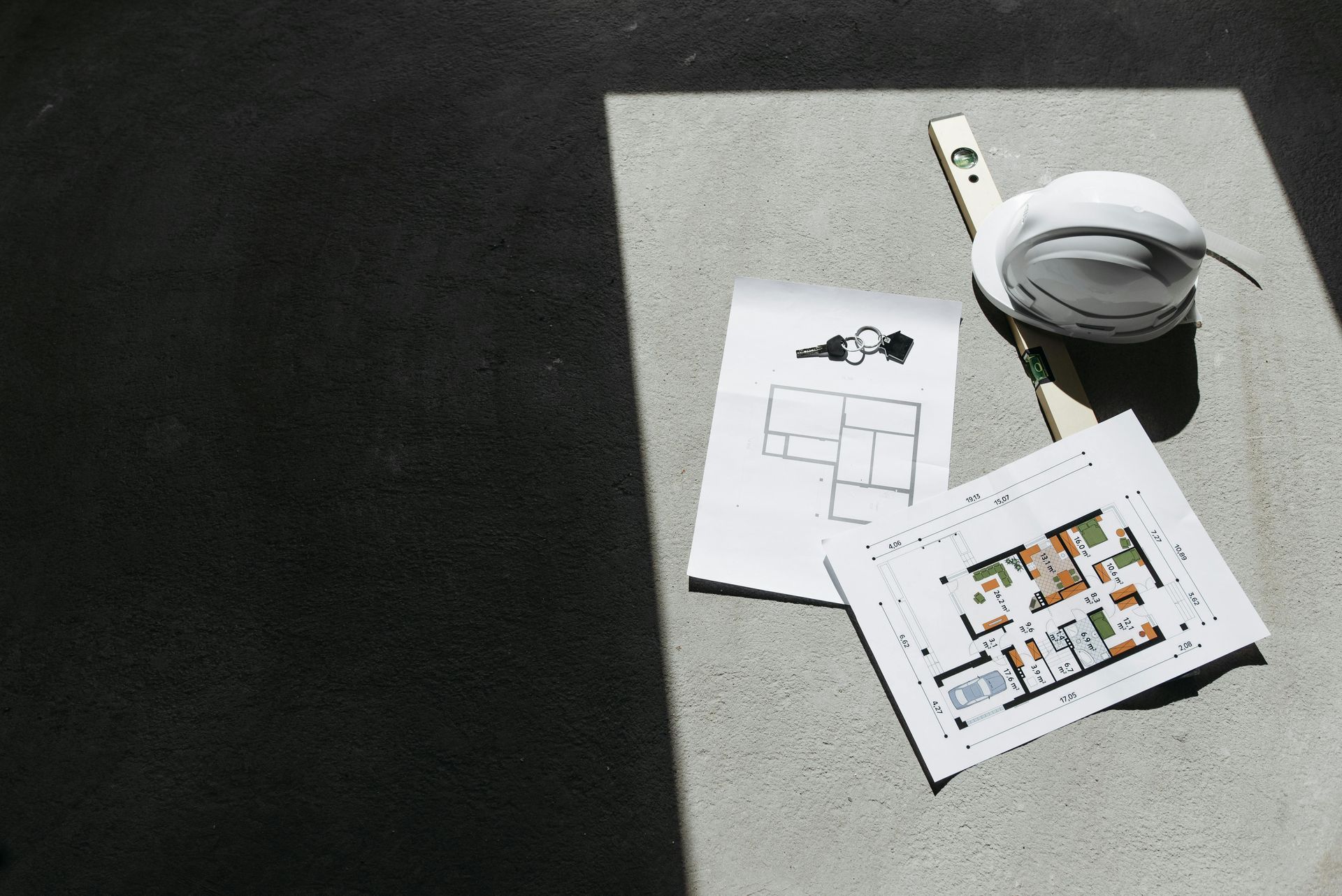 A backyard with a wooden deck , stairs , and a tree.