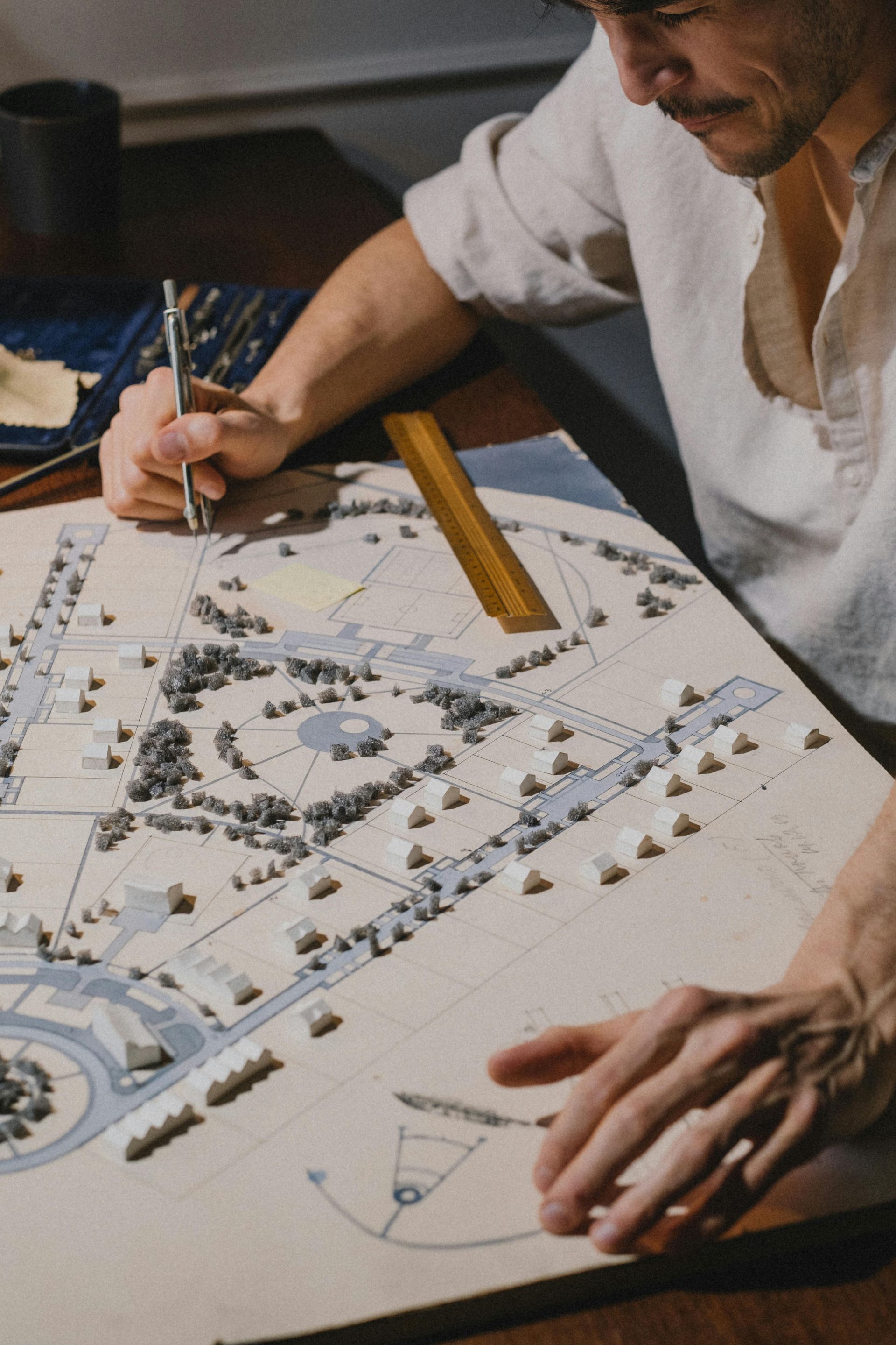 A woman works at a table with a site plan laid out on it.