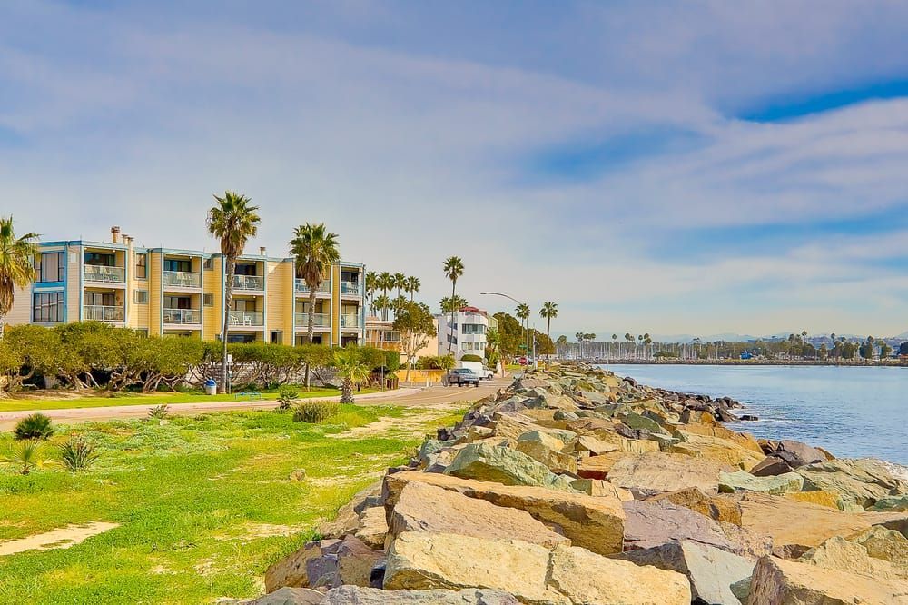 Apartment buildings on the coast with palm trees.