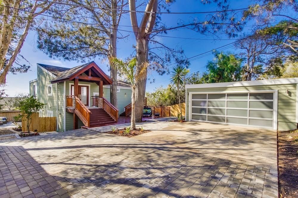 A house with a garage and a driveway in front of it.