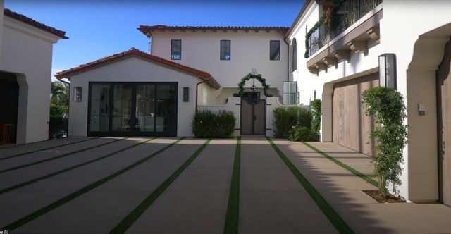A large white house with a large driveway in front of it.