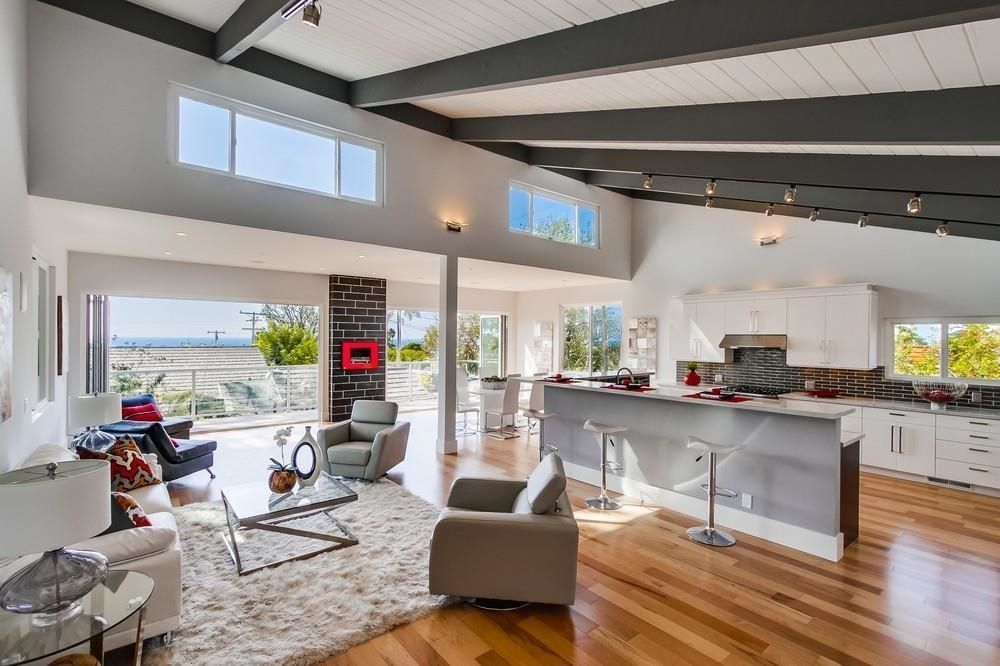 A living room and kitchen in a house with hardwood floors.