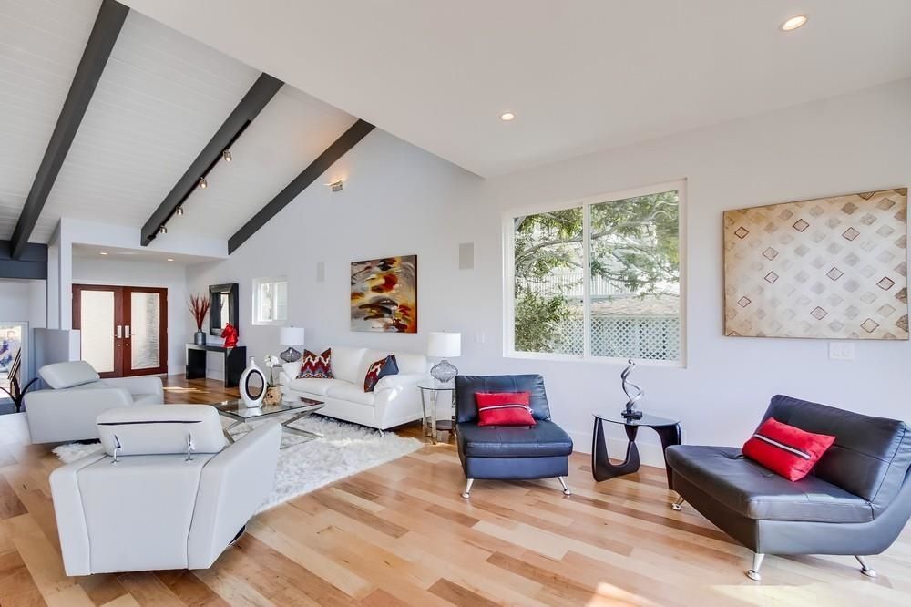 A living room with a vaulted ceiling and hardwood floors