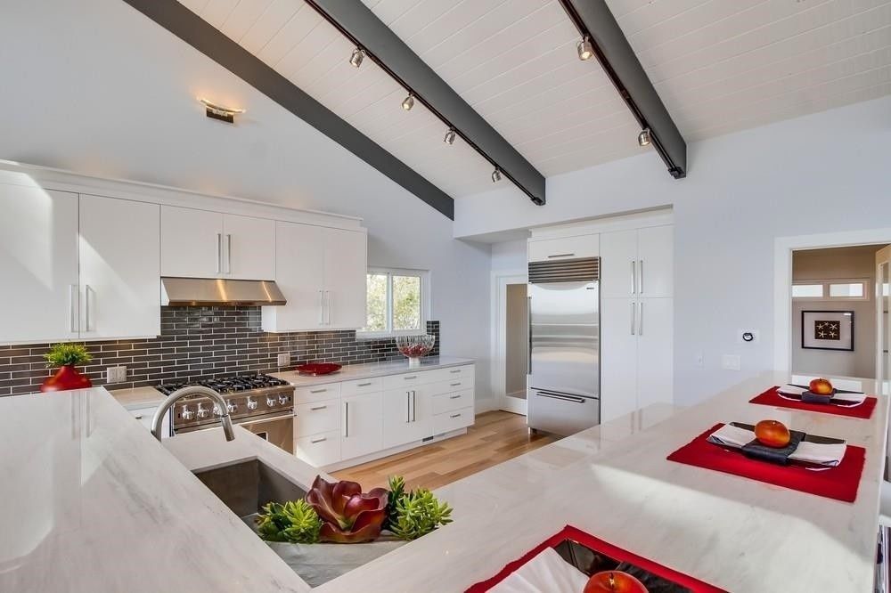 A kitchen with white cabinets and stainless steel appliances
