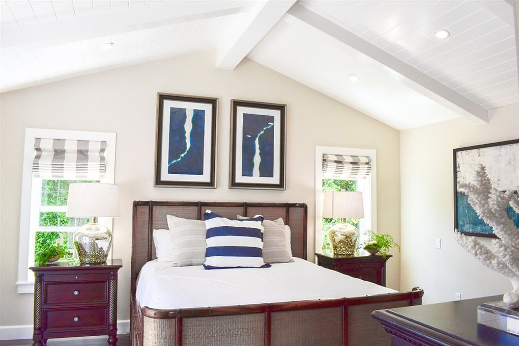 A bedroom with a vaulted ceiling and a large bed