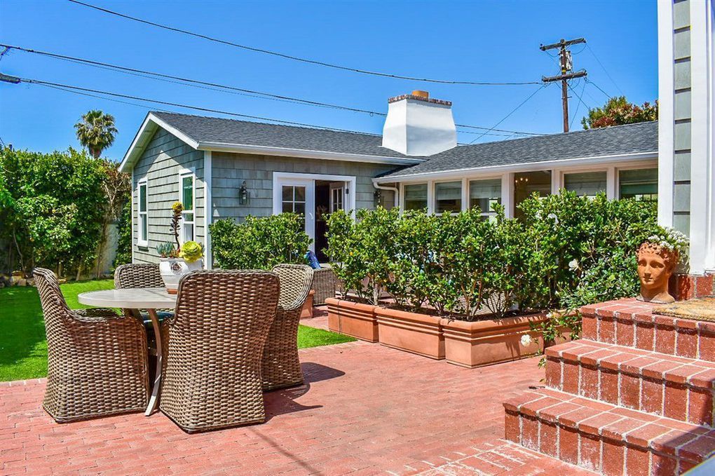 A patio with a table and chairs in front of a house.