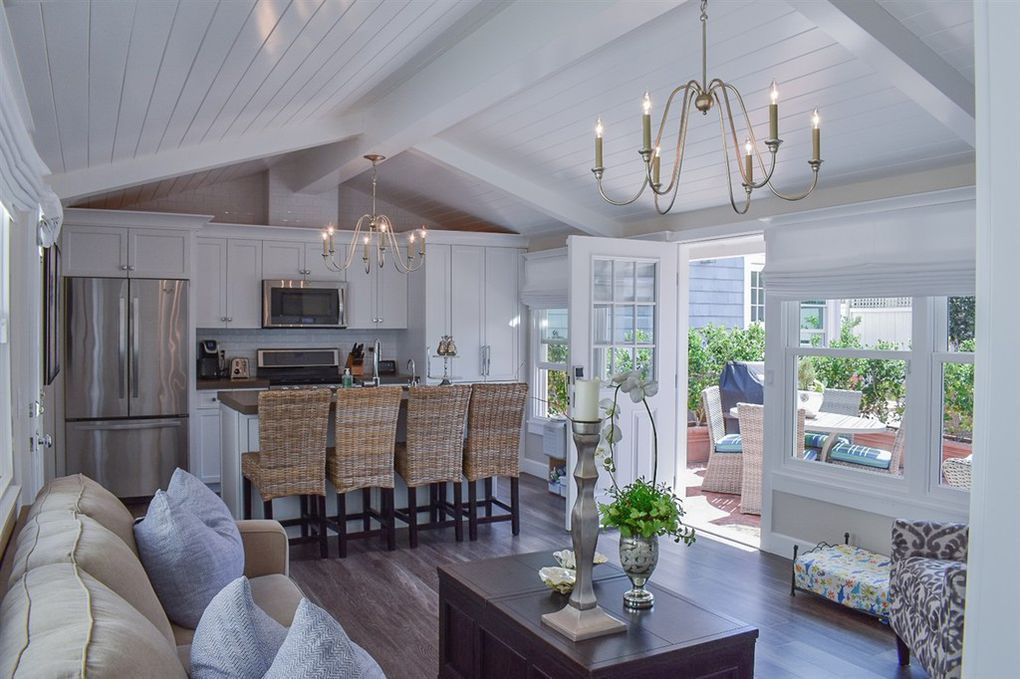 A living room with a couch, table, chairs, and a chandelier.