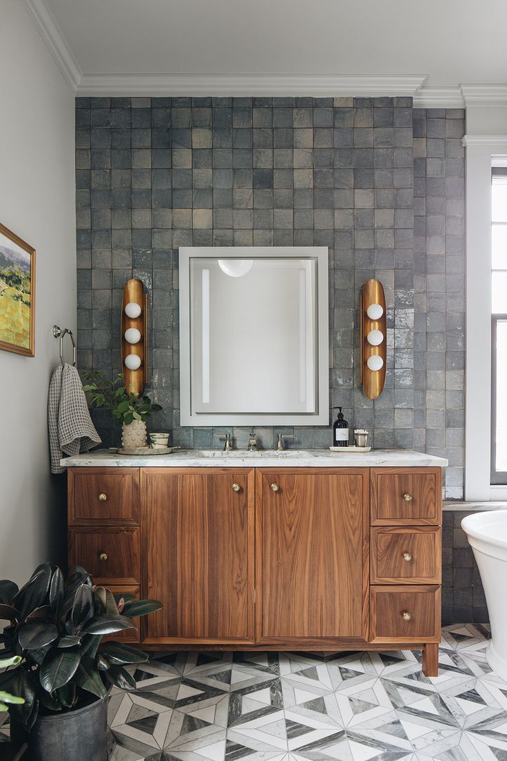 A bathroom with two sinks , a mirror and a bathtub.