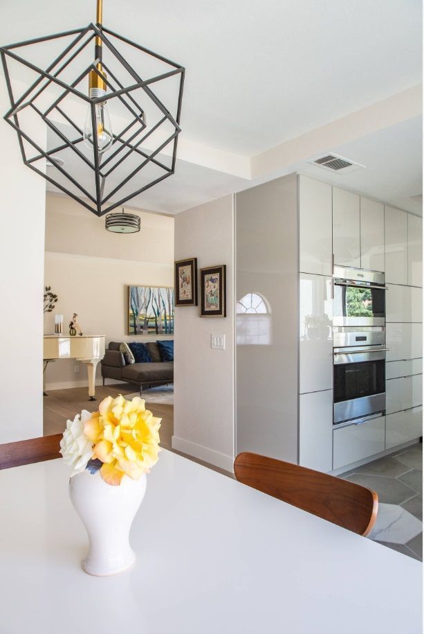 A vase of flowers sits on a table in a kitchen