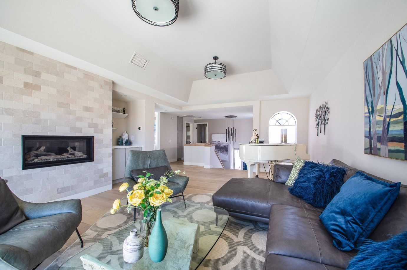 A living room with a couch, chairs, coffee table, and fireplace.