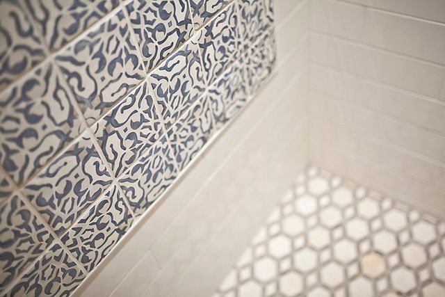 A bathroom with blue and white tiles on the wall and floor.