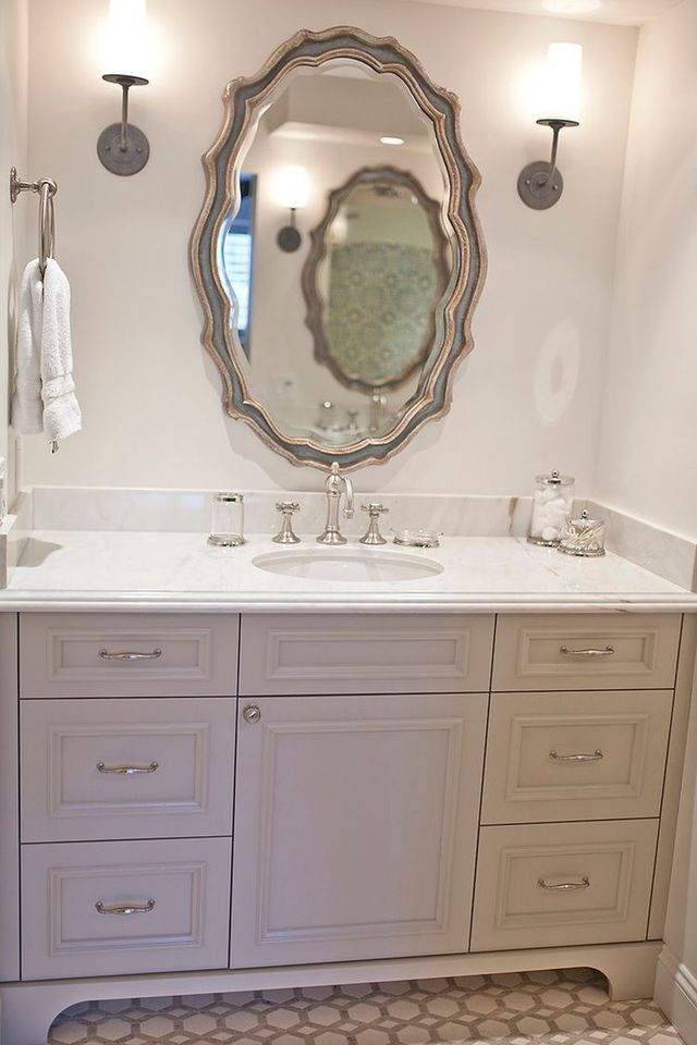 A bathroom with a sink , mirror and drawers