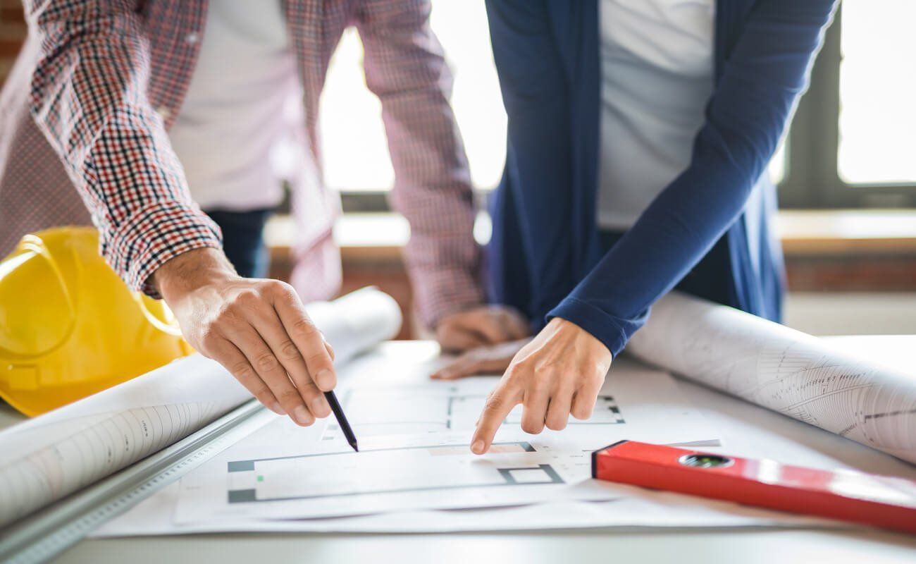 A man and a woman review plans on a table.