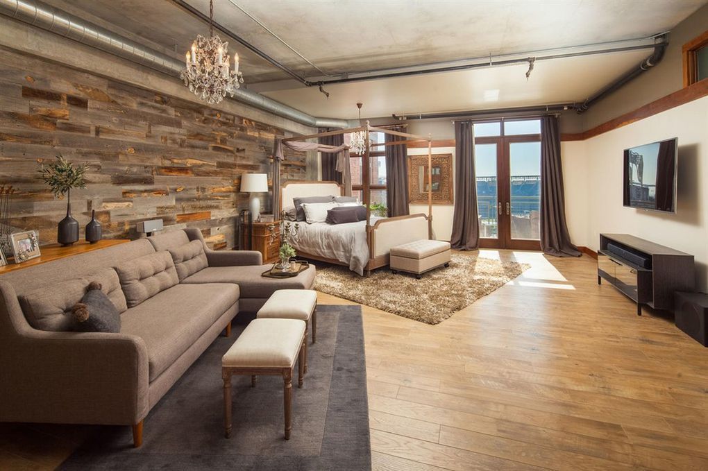 A living room with a couch , chairs , and a bed.