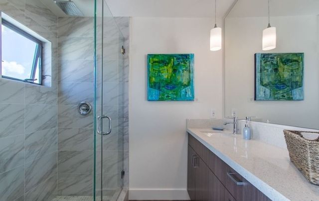 A bathroom with a walk in shower , sink , and mirror.